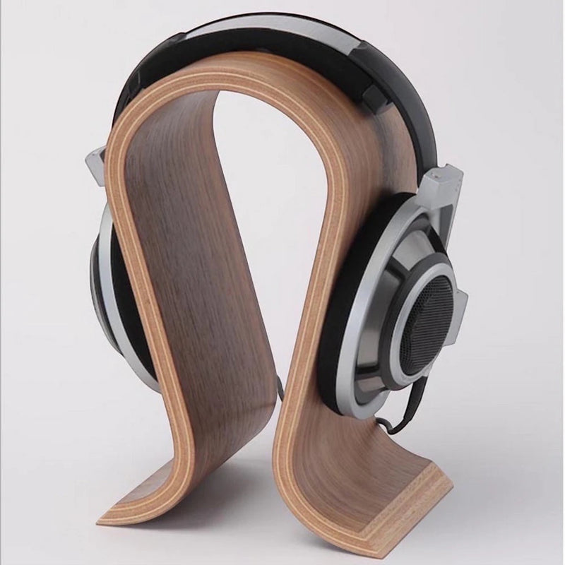 Belcrest walnut bent plywood headphone stand with U-shaped design supporting headphones. Natural wood grain.