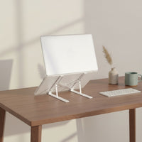 Belcrest adjustable aluminum laptop stand holding a silver laptop on a wooden desk. Ergonomic design for improved posture.